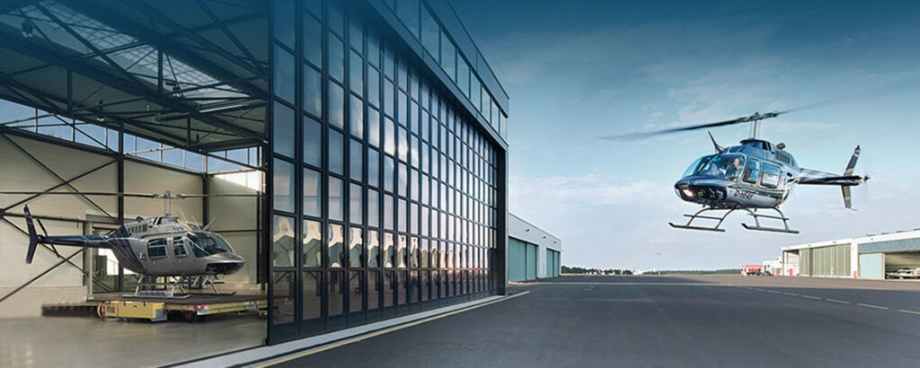 Bell 206 schwebt vor dem kayfly Hangar am Flughafen Siegerland